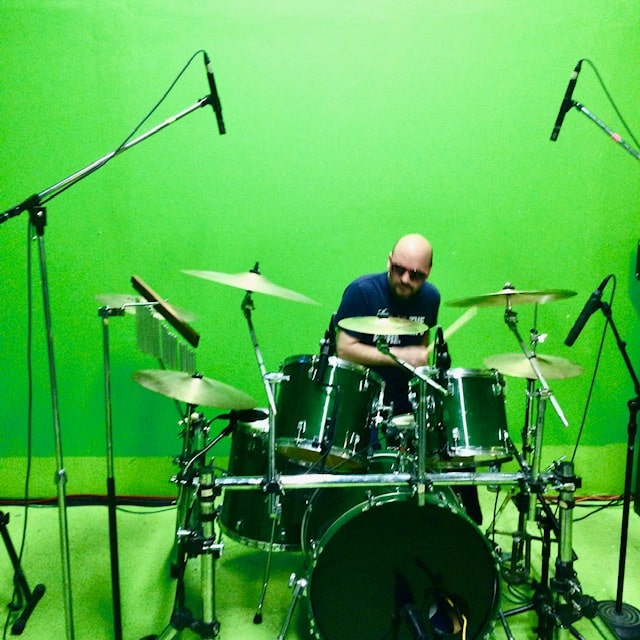 Drummer surrounded by mic stands at the kit
